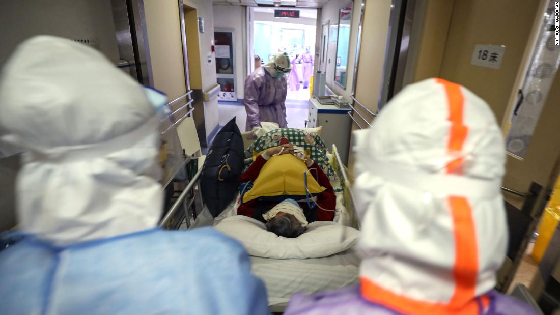 Medical staff transport a coronavirus patient within the Red Cross hospital in Wuhan on February 28. 