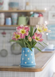 She put the pitcher of flowers over there on the counter.